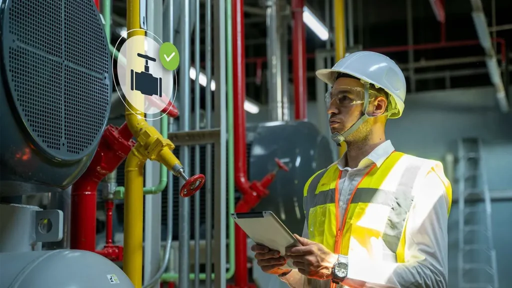 Engineer with a tablet inspecting industrial plant piping and equipment